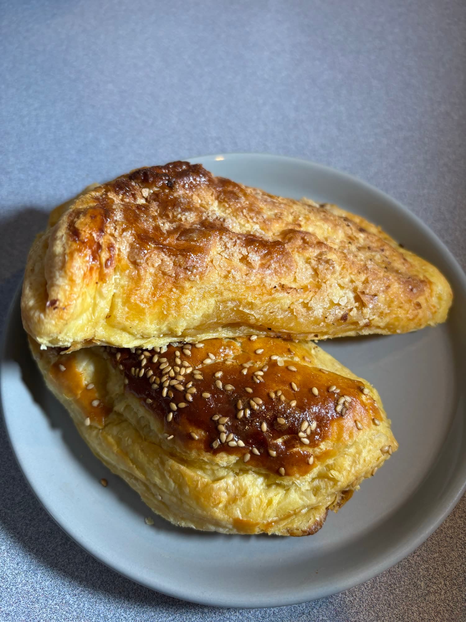Dos pastes de hojaldre con ajonjolí recién horneados en un plato