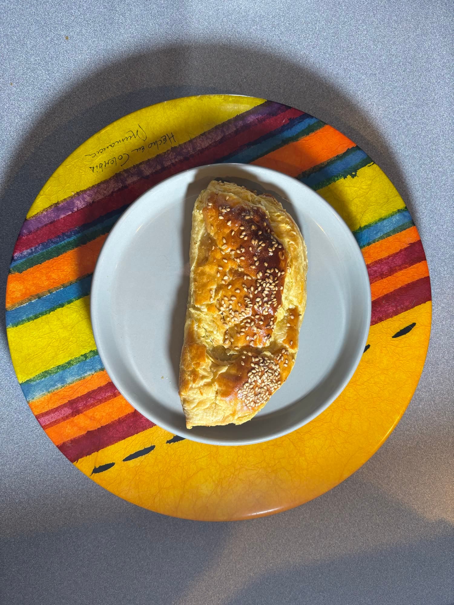 Paste con ajonjolí servido en un plato sobre un mantel de colores